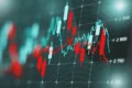 A financial chart with red and white candlesticks shows fluctuating stock prices, overlaid with a blue line graph. Numbers along the side indicate price levels, creating a dynamic and analytical atmosphere.