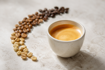 What Is Blonde Espresso in a ceramic cup with light roast espresso beans beside it