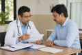 Authorised Medical Attendant reviewing medical documents and reimbursement claim form with an employee in a healthcare office
