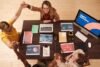 Overhead view of a diverse team celebrating around a desk with laptops and digital marketing materials, conveying teamwork and success.