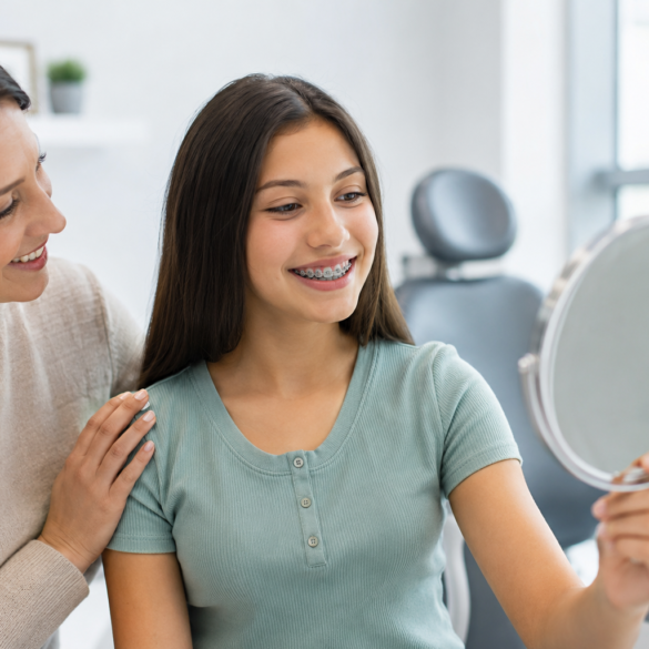 Teen smiling during orthodontic consultation with parent learning about Braces for Teens