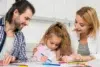 Singleton preschool learning moment with parents helping a young child draw and practice creativity at home