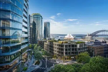 A vibrant cityscape featuring modern glass buildings, a lush rooftop garden, Sydney Opera House, and the Harbour Bridge under a clear blue sky.