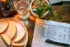 Apple slices on a plate, a glass of water, and a calorie counter sheet on a wood table, creating a health-focused, organized atmosphere.