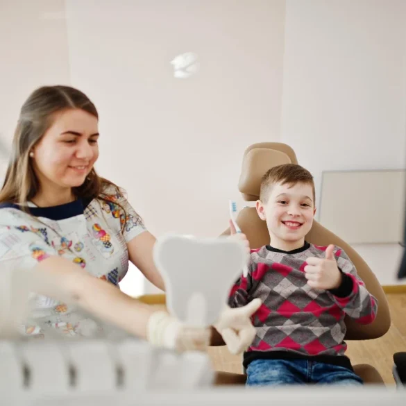 A young boy gives a thumbs up while sitting in a dental chair, showing how family dentistry blends aesthetic results with a positive patient experience for all ages.
