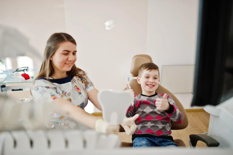 A young boy gives a thumbs up while sitting in a dental chair, showing how family dentistry blends aesthetic results with a positive patient experience for all ages.