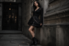 Woman wearing a black Goth Skirt styled with boots, lace top, and dark fashion accessories in a modern gothic outfit