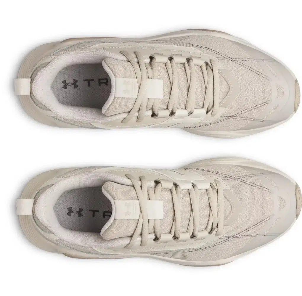 Top view of a pair of light beige athletic sneakers with sleek design, showing laces and padded interior. The brand logo is visible inside.