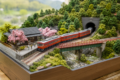 Hakone Railway Model Layout with a miniature train passing through Japanese mountain scenery, tunnels, bridges, trees, and a small station