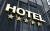 Gold "HOTEL" sign with five stars below, mounted on a reflective glass building facade. The image conveys luxury, elegance, and high-quality service.