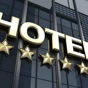 Gold "HOTEL" sign with five stars below, mounted on a reflective glass building facade. The image conveys luxury, elegance, and high-quality service.