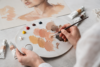 Artist mixing realistic skin color paint shades on a palette for portrait and craft artwork