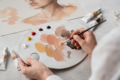 Artist mixing realistic skin color paint shades on a palette for portrait and craft artwork