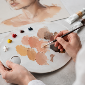 Artist mixing realistic skin color paint shades on a palette for portrait and craft artwork