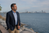 A calm South Lake Michigan shoreline with a subtle city and industrial background representing public search context around Mauricio Pincheira.
