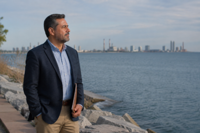 A calm South Lake Michigan shoreline with a subtle city and industrial background representing public search context around Mauricio Pincheira.
