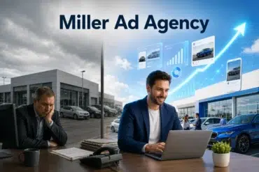 Man in a blue suit smiles at a laptop in a modern office. Imagery of digital graphs and cars suggest thriving business. Overcast sky outside.
