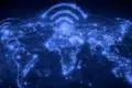 A glowing blue map of the world shows connected lines and Wi-Fi symbols above continents, symbolizing global communication and connectivity.