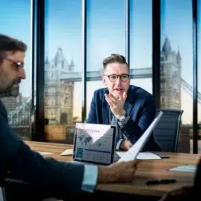 A professional group of accountants in a high-rise London office reviews financial growth charts on a laptop, illustrating the role of a CPA in an IPO process.