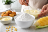 Starch of Maize powder in a bowl with corn kernels and cooking ingredients on a kitchen table
