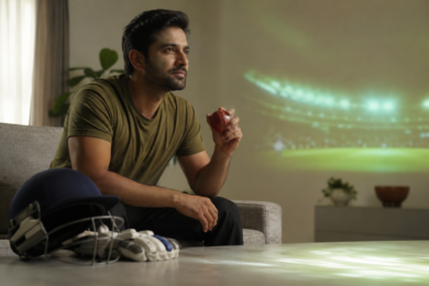 Cricket fan watching a live match online on a mobile device with a stadium scene in the background
