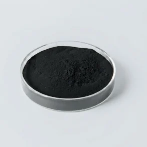 Black powder in a clear round petri dish on a light gray background.