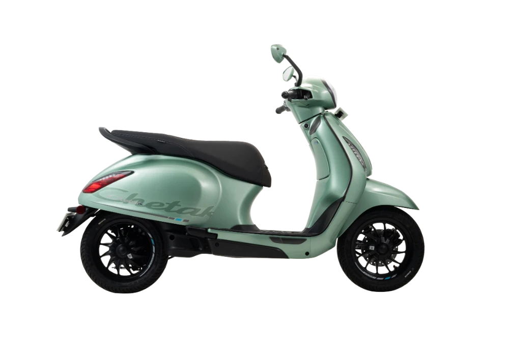 A mint green Chetak scooter with black wheels and seat is shown in profile against a black background.