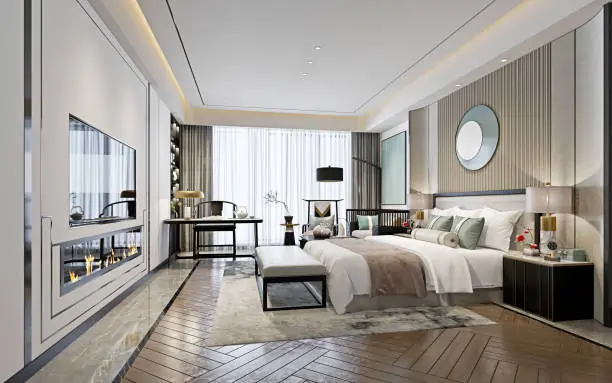 Luxurious modern bedroom with a large bed adorned with cushions, a sleek fireplace, a writing desk by the window, and soft lighting creating a cozy atmosphere.
