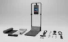 Foldable treadmill with built-in screen, accompanied by various fitness accessories and mats arranged on a plain surface.