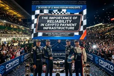 Four racing drivers stand on a podium with a crowd cheering in the background and a large screen displaying "The Importance of Reliability in Crypto Payment Infrastructure" at the 24 Hours of Le Mans.