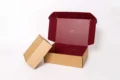 Opened brown cardboard box with a deep red interior and the word "TUSTING" printed inside the lid.