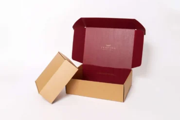 Opened brown cardboard box with a deep red interior and the word "TUSTING" printed inside the lid.
