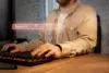 Man typing on a backlit keyboard with a search bar graphic overlaid.