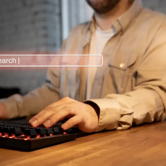 Man typing on a backlit keyboard with a search bar graphic overlaid.