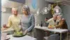 Two senior women cut a cake in a kitchen decorated with balloons and modern lights, while two senior men take a selfie in the background.