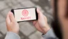 Person holding a smartphone displaying a red target symbol and the word "TARGET" in red text.