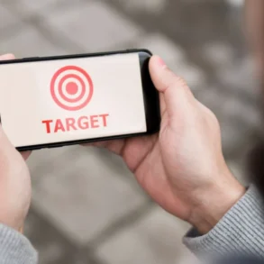 Person holding a smartphone displaying a red target symbol and the word "TARGET" in red text.