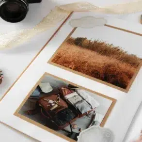 Open scrapbook with travel-themed photos, camera, and colored pencils.