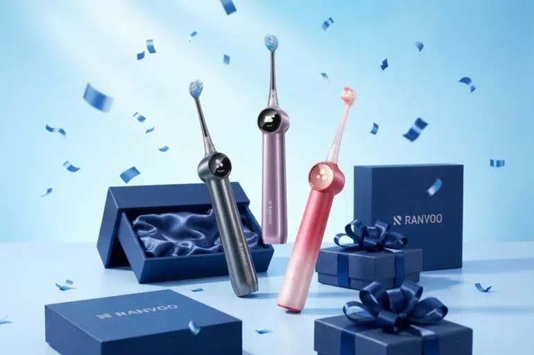 Three colorful electric toothbrushes stand upright amid floating blue confetti. Nearby are elegant blue gift boxes with silky interiors and dark blue ribbons, creating a festive and modern vibe.