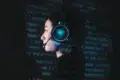 Profile view of a person wearing illuminated headphones with a microphone against a dark background filled with glowing blue code.