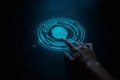 A finger touches a glowing blue fingerprint scanner on a dark background.