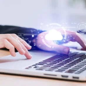 Close-up of hands typing on a laptop with a glowing cloud icon and network graphics overlayed.