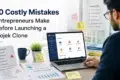 Man reviewing business launch documents and dashboard on laptop, with "10 Costly Mistakes Entrepreneurs Make Before Launching a Gojek Clone" text overlay.