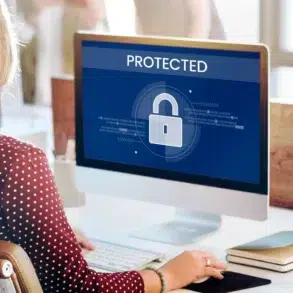 Woman at computer with screen displaying a large padlock icon and the word "PROTECTED".