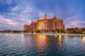 Atlantis, The Palm hotel illuminated at dusk with a view of the Arabian Gulf and beach.