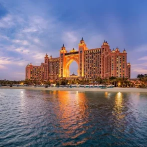 Atlantis, The Palm hotel illuminated at dusk with a view of the Arabian Gulf and beach.