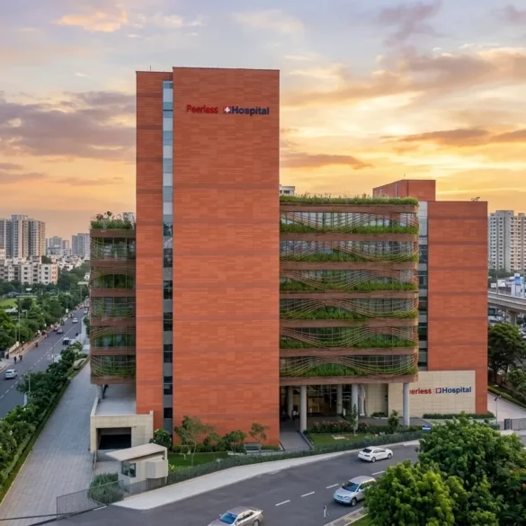 Modern brick hospital building with green vertical gardens at sunset in a cityscape.