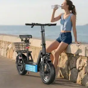 A young woman in shorts and a sleeveless top sits on a stone seawall next to a parked black electric scooter with a basket, drinking water from a bottle with the ocean in the background.