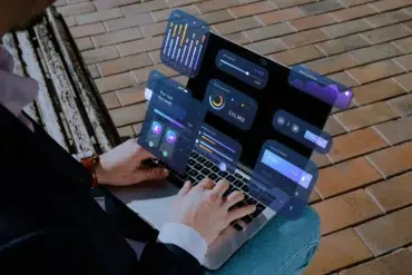 Person using a laptop with floating UI elements displaying financial data and graphs.