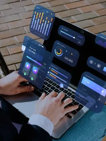 Person using a laptop with floating UI elements displaying financial data and graphs.